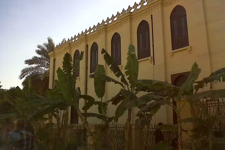 Exterior of a historic Coptic Cairo church with palm trees, a stop on a private Cairo day tour