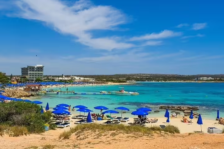 Coral Bay beach near Paphos with turquoise water and umbrellas, on a Paphos and Western Cyprus tour