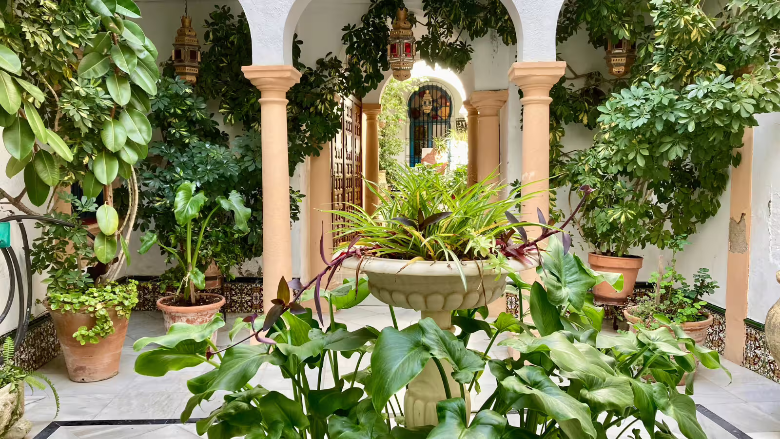 Traditional Cordoba courtyard with arches, fountain and lush plants, seen on a small group walking tour