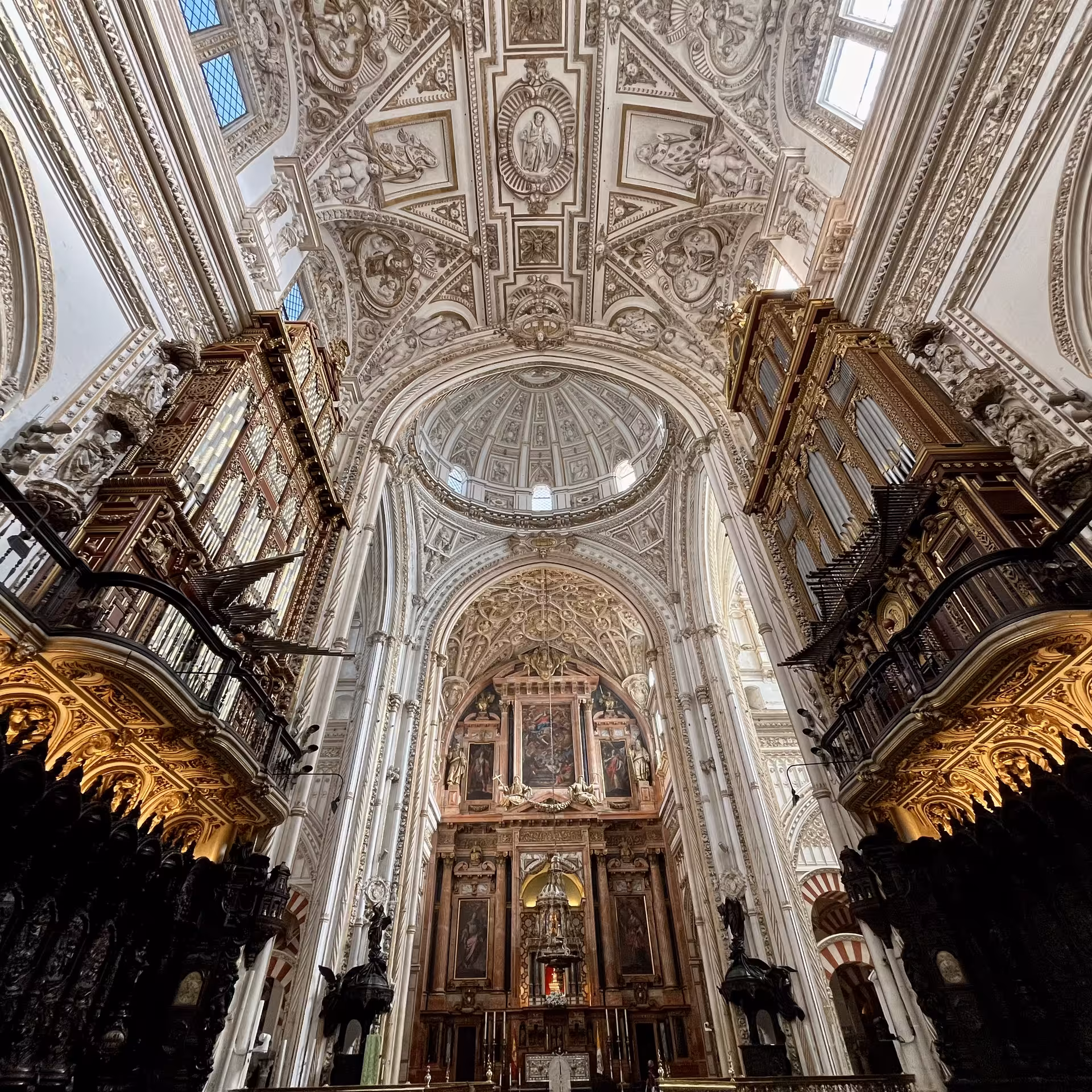 Córdoba Mezquita-Catedral nave with ornate dome, choir stalls and altarpiece on Monumentos Locales tour