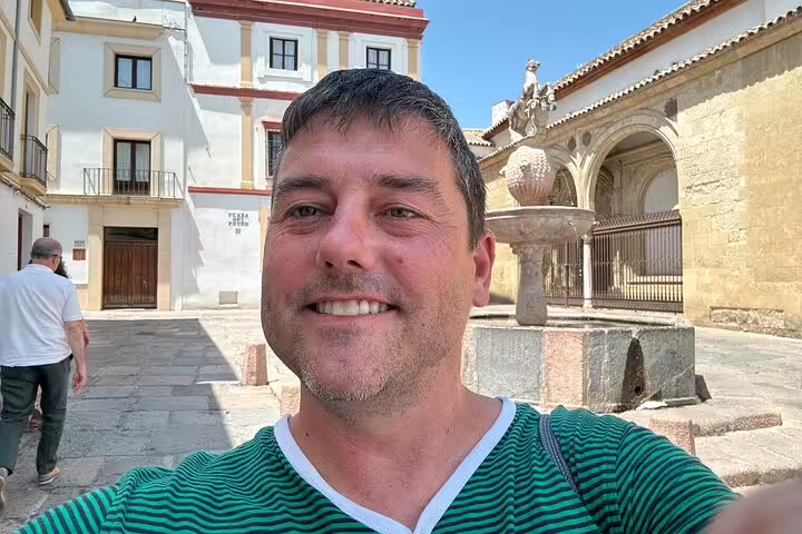 Traveler selfie in Córdoba plaza with Pineapple Fountain, part of a scavenger hunt and city highlights tour