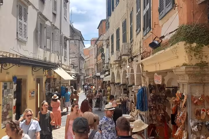 Crowded Corfu Old Town lane lined with souvenir shops and shutters, a must-see stop on the Top 5 Corfu tour