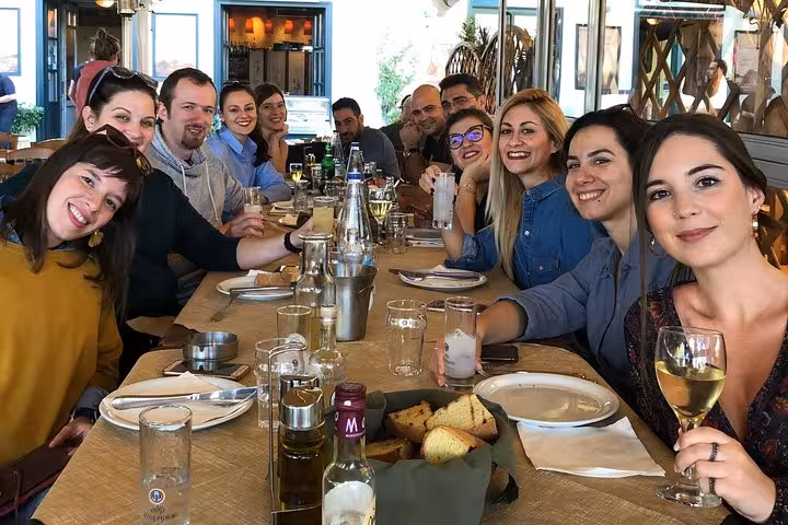 Tour group enjoying Greek lunch and wine on Corinth Canal day trip from Athens with tasting and pottery