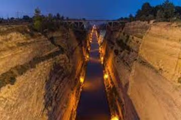 Illuminated Corinth Canal at dusk, a highlight stop on the Ancient Corinth half-day tour from Athens