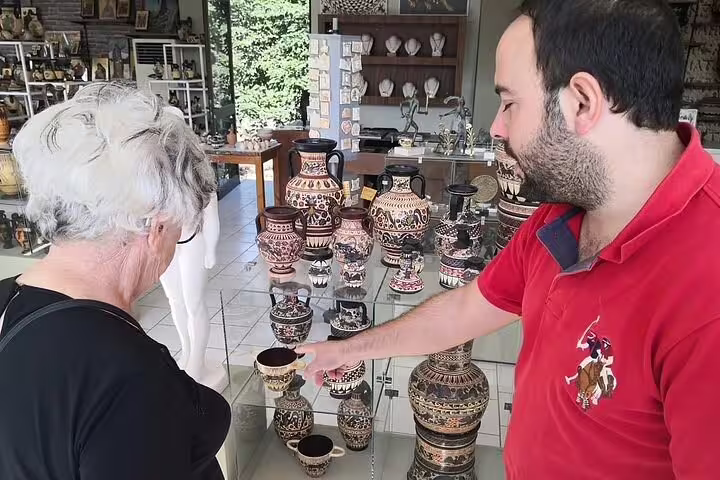 Traveler browsing handmade Greek pottery in Corinth, cultural shopping stop on half-day Ancient Corinth tour