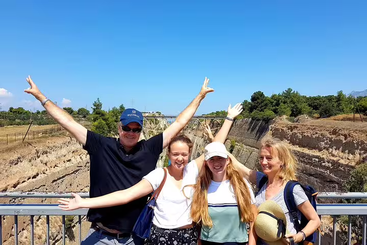 Travelers posing at the Corinth Isthmus Canal viewpoint on a private Athens day tour to Blue Lagoon and Epidaurus