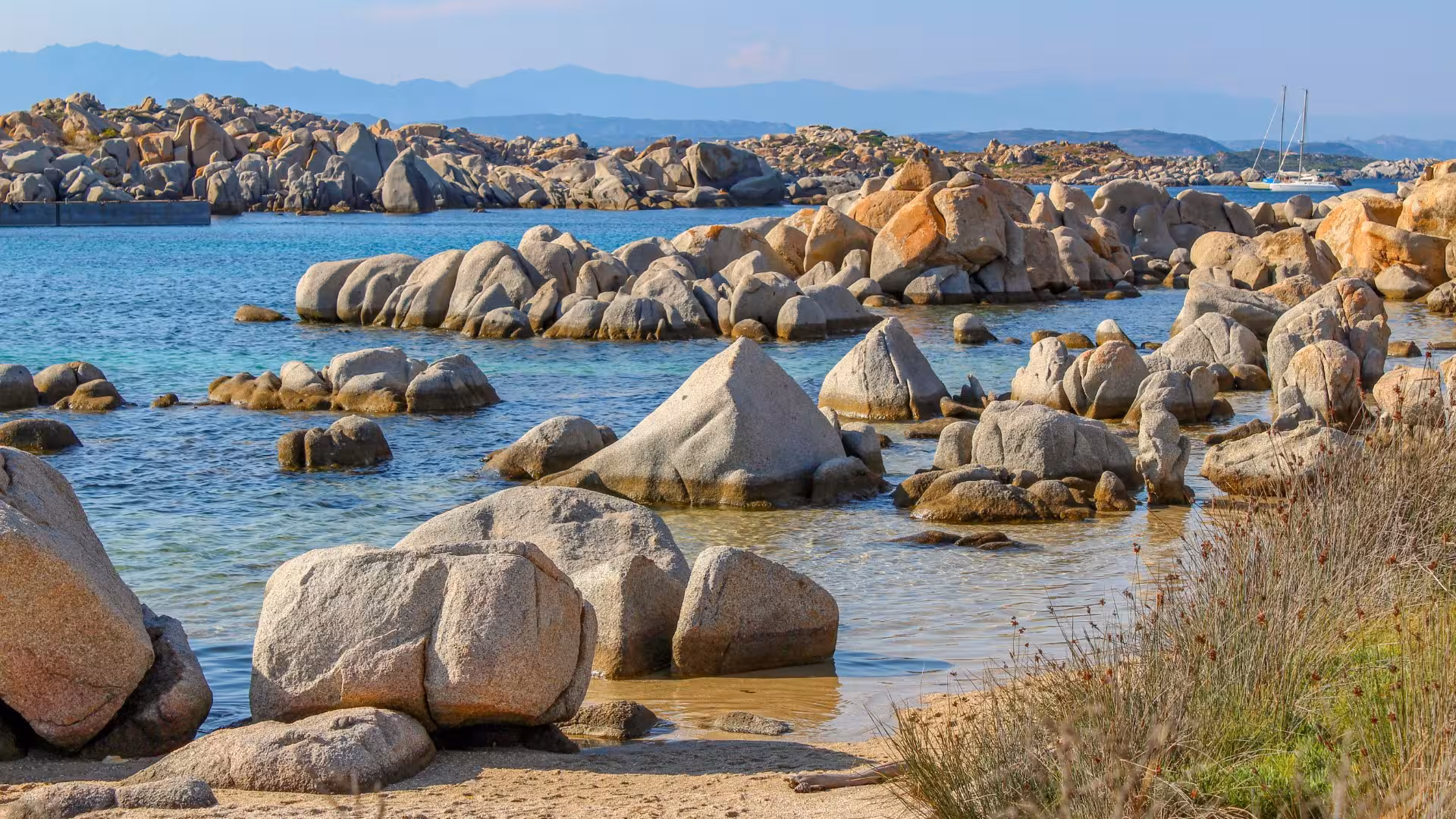 Stunning rocky coastline of southern Corsica with clear blue waters, ideal for exploring on a wooden boat tour.