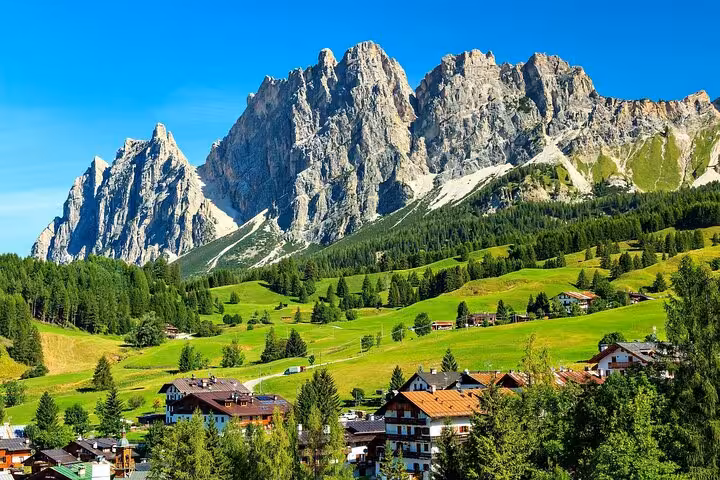 Marvel at the stunning Dolomite peaks surrounding Cortina d'Ampezzo, a scenic beginning to your Venice journey.