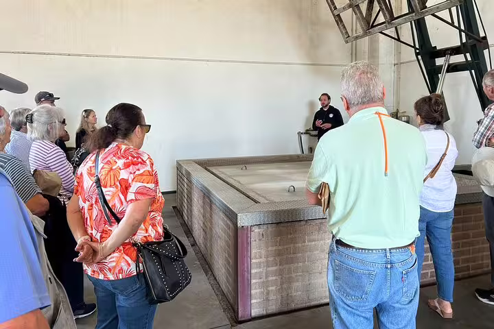 Visitors gather around a guide at the Cortiza and Herdade Alentejo Factory, learning about cork production.