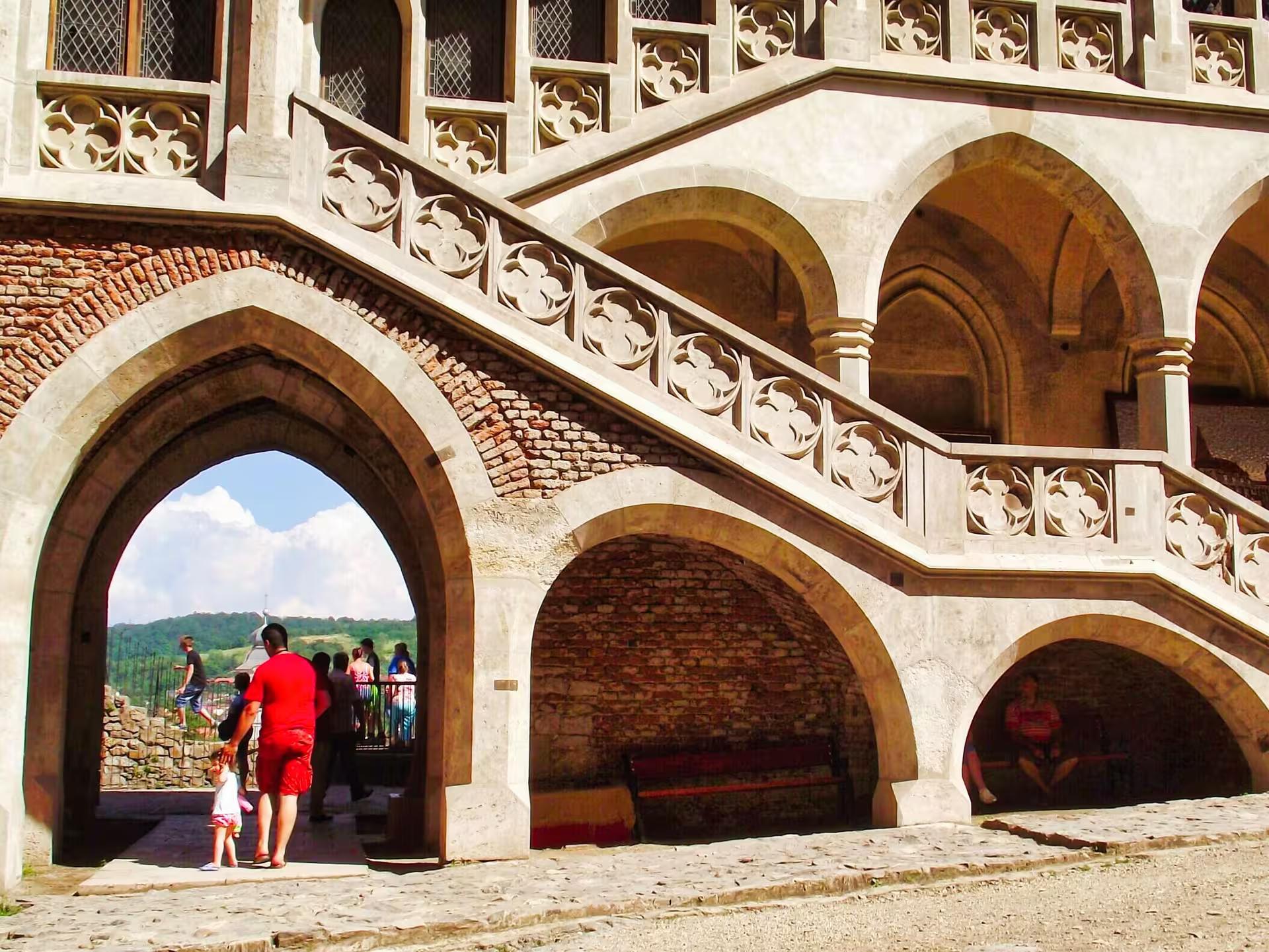 Gothic arched entrance and ornate stone staircase of Corvin Castle on a day trip from Cluj-Napoca Romania
