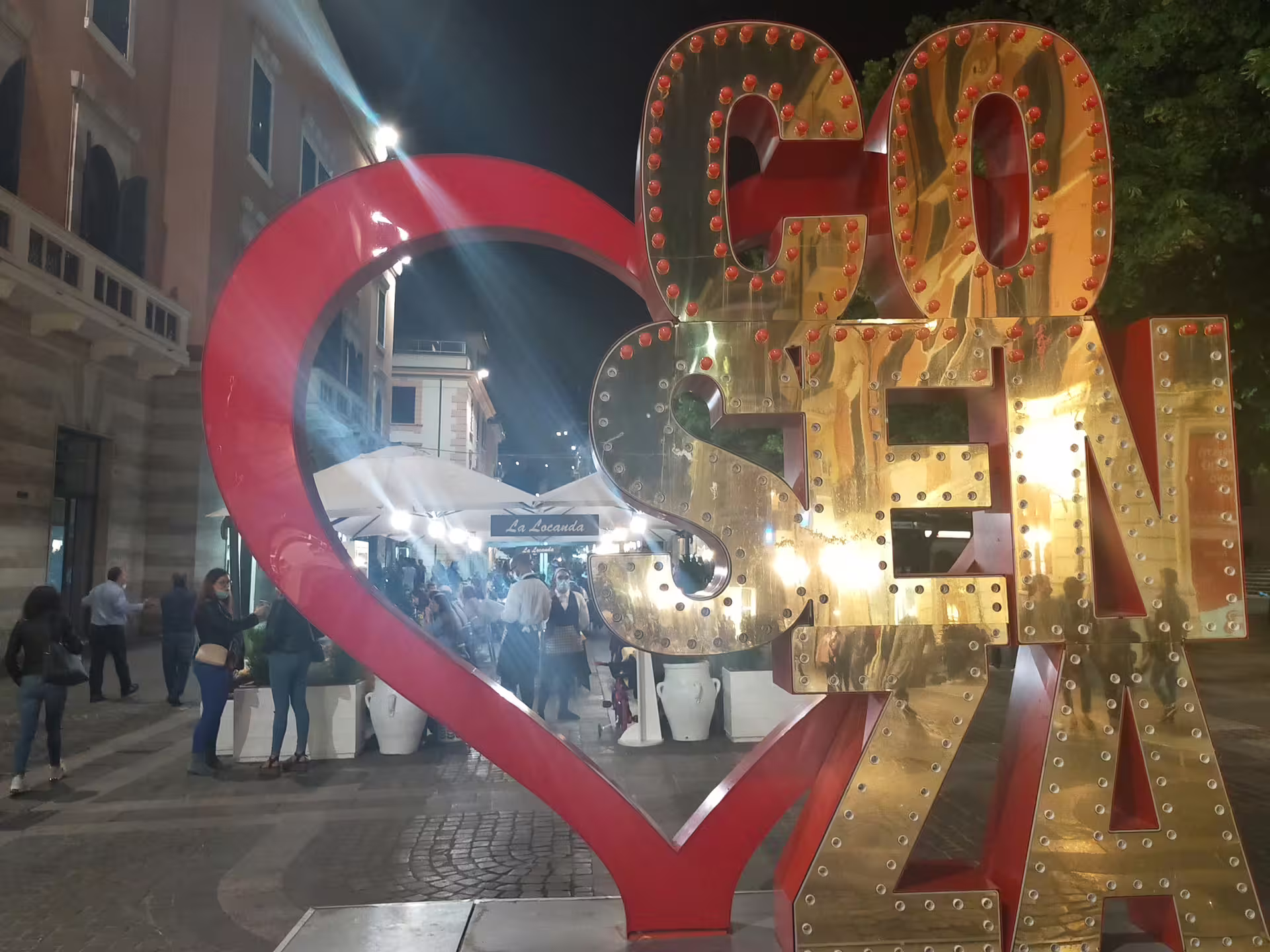 Illuminated Cosenza heart sign at night, vibrant Calabria street scene on Sila Park and Presila gastronomy trip