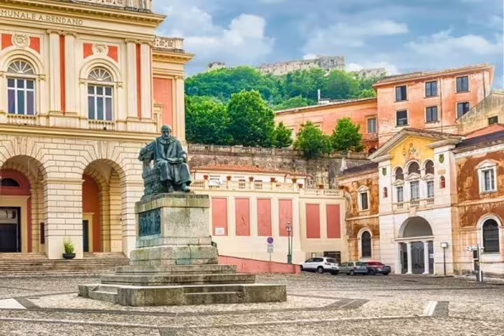 Historic square in Cosenza with grand theater, statue and hillside views on a private walking tour of art and culture