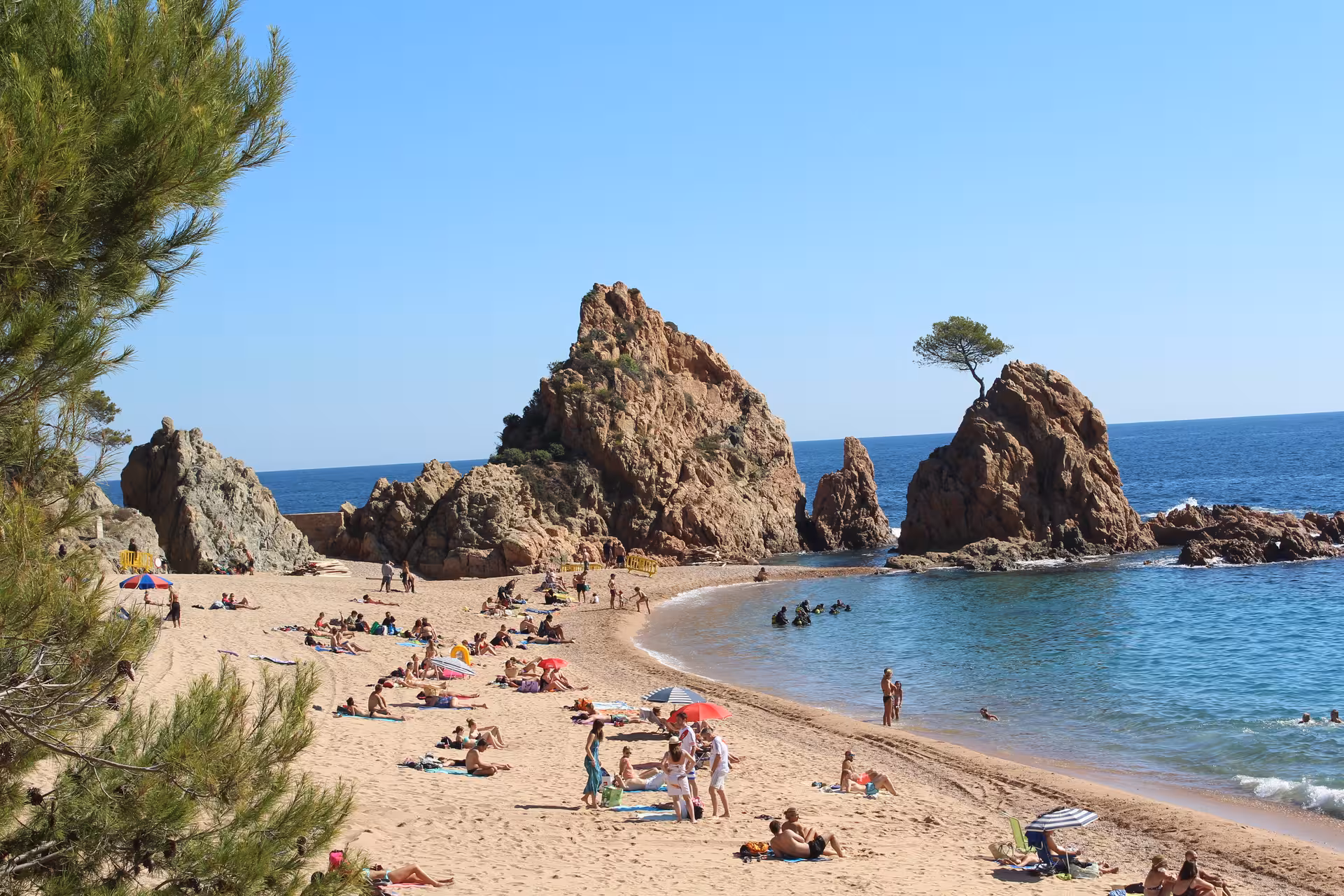 Costa Brava beach cove day trip from Barcelona with golden sand, rocky cliffs and crystal-clear water