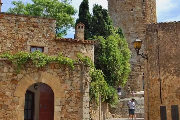 Explore medieval charm with stone buildings and towers in a historic Costa Brava village.