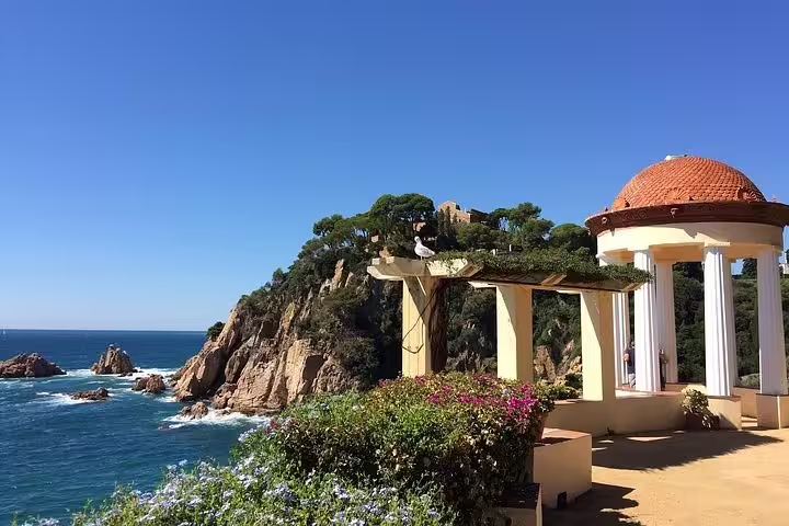 Scenic view of a coastal gazebo and rocky cliffs in Costa Brava on a sunny day.