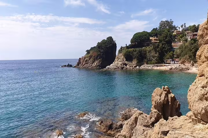 Picturesque cove with clear blue waters and rocky cliffs in Costa Brava.