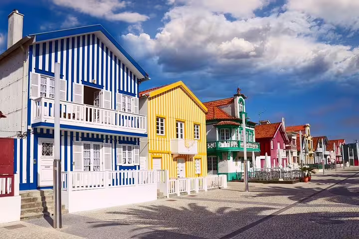 Colorful striped houses of Costa Nova under a vibrant sky, showcasing traditional Portuguese architecture.