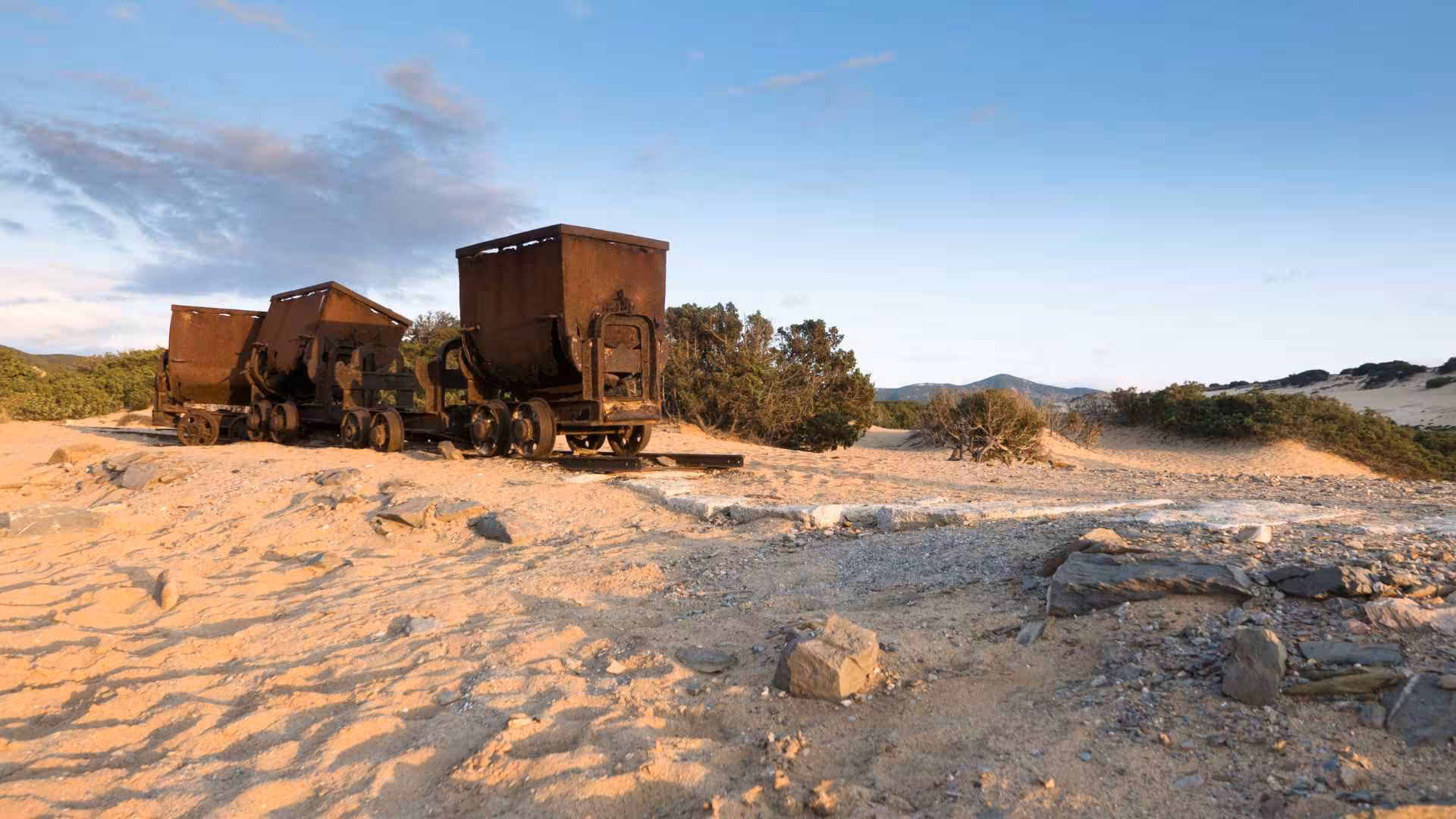 Abandoned mining carts on sandy dunes during Costa Verde off-road exploration trip.