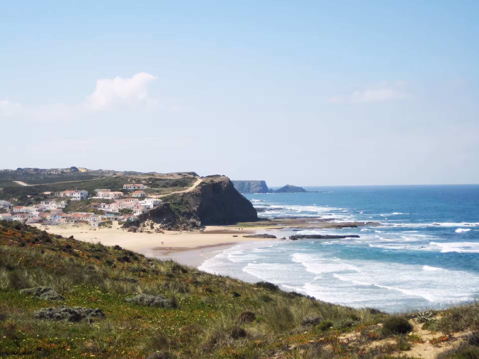 Panoramic view of Costa Vicentina wild coast with whitewashed village, golden beach and Atlantic waves in southwest Portugal