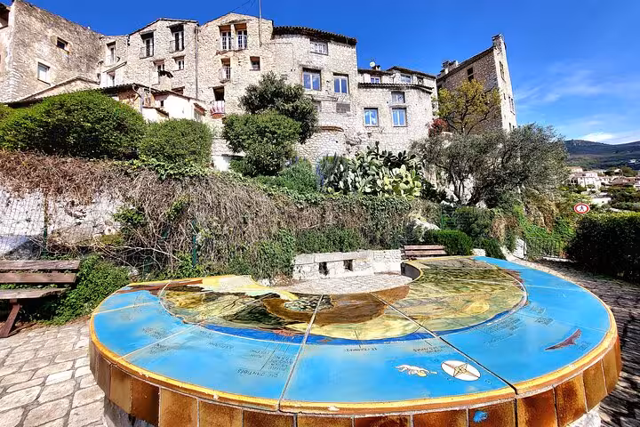 Charming stone buildings and a colorful map table in a picturesque village in the Côte d'Azur hinterland.