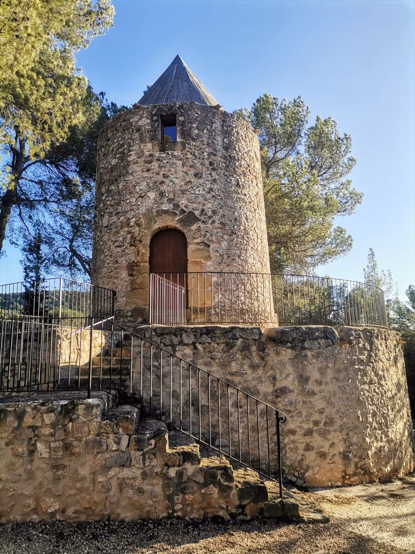 Historic stone tower at a Coteaux d'Aix-en-Provence vineyard stop with views toward Sainte-Victoire Mountain.