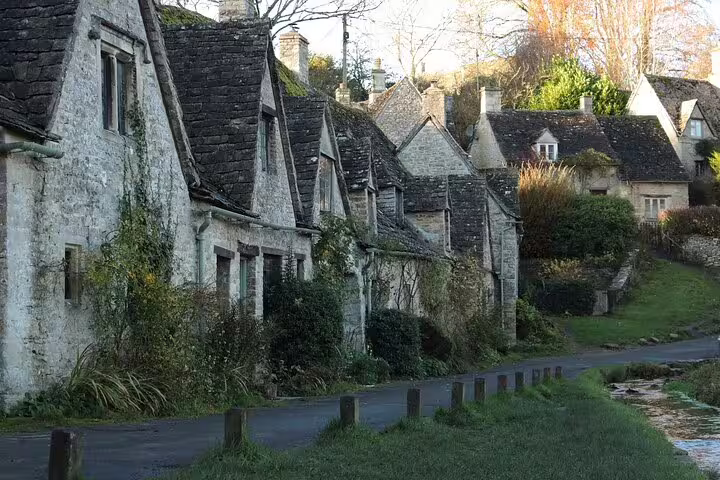 Traditional Cotswolds stone cottages beside a quiet lane, scenic village stop on a day trip from London