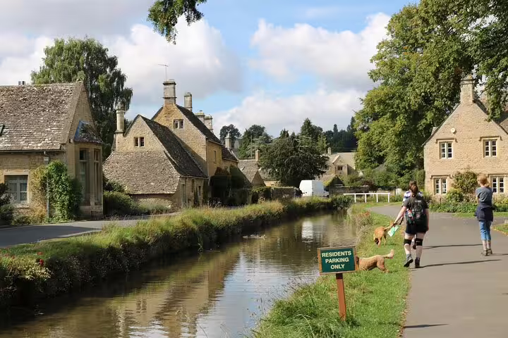 Canal-side walk past honey-stone cottages in a Cotswolds village, featured on a London day trip tour