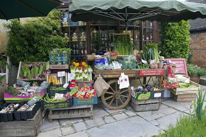 Cotswolds village farm shop produce stall on a day trip from London, showcasing local fruit and veg
