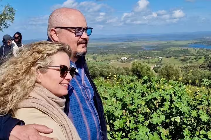 Couple enjoying scenic views of Alentejo vineyards during a private full-day wine tour from Lisbon to Évora.