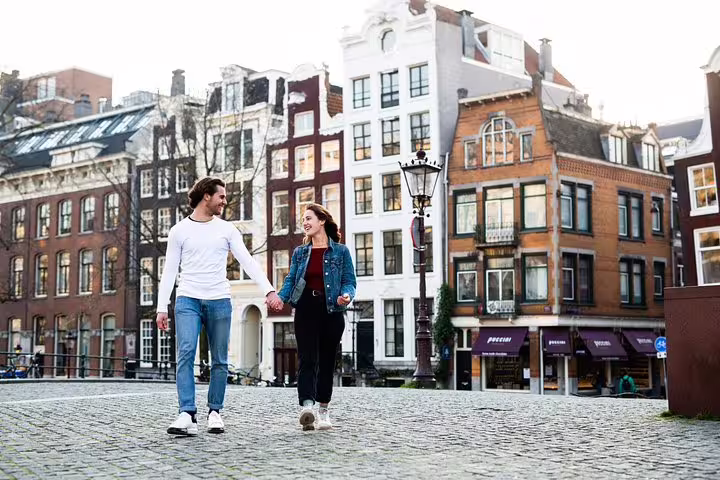 Couple enjoying a scenic walk through Amsterdam's charming streets, featuring historic architecture on the Amstagram Tour & Moco Experience.