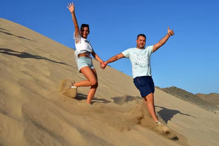 Couple running down sandy dunes in Sharm El Sheikh, fun stop during sunrise or sunset ATV quad safari tour