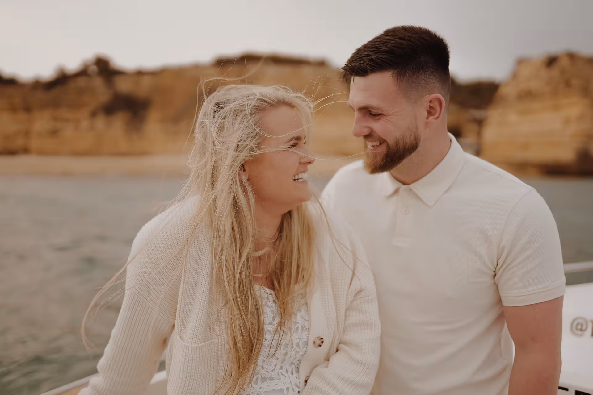 Smiling couple on a private Benagil Caves boat at sunset, enjoying a romantic Algarve coast tour in Portugal