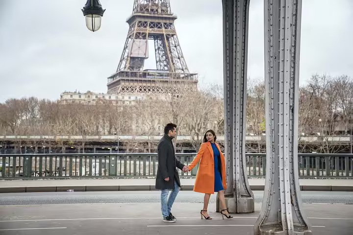 Couple holding hands on Bir-Hakeim Bridge with Eiffel Tower backdrop, Paris proposal photography shoot