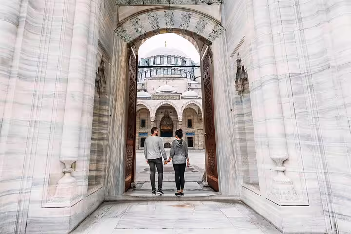 Couple walking through Blue Mosque courtyard archway, Istanbul personal travel photographer tour photo shoot