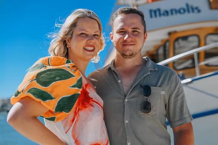 Smiling couple posing in front of a boat in Elounda, perfect for a memorable private photoshoot experience.