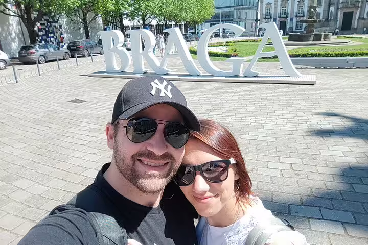 Couple selfie by the Braga sign in Portugal, starting a self-guided scavenger hunt and city sights tour