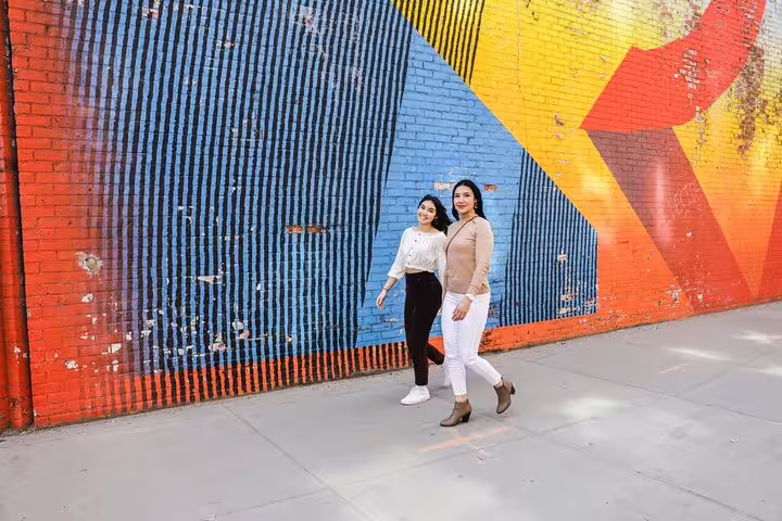 Couple posing by colorful Brooklyn street mural on a personal photography tour in Brooklyn and DUMBO NYC