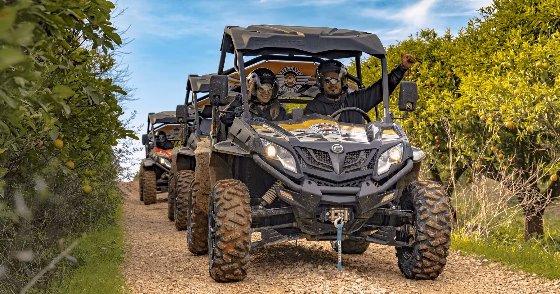 Smiling couple on a guided buggy tour driving through Algarve orange groves on a scenic off-road adventure