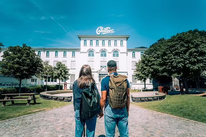 Couple exploring the Cailler chocolate factory on a sunny day during the Gruyères cheese and chocolate tour.
