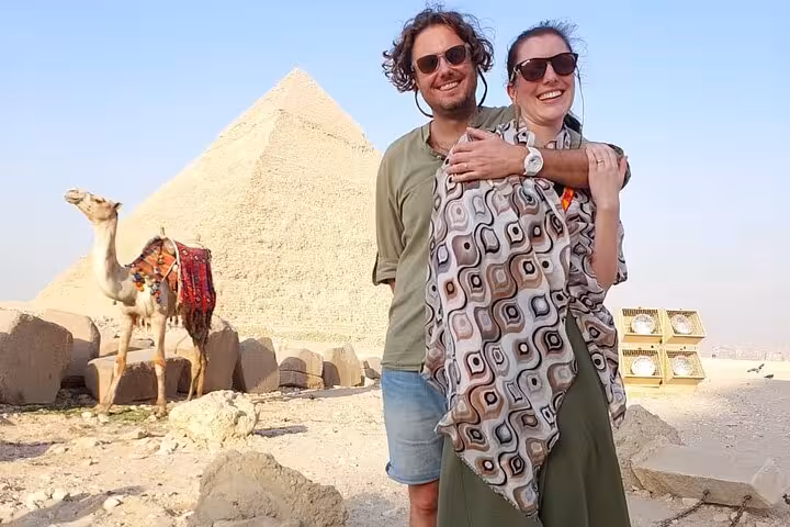 Couple with camel near the Pyramids of Giza during a 3-day all-inclusive Cairo tour and desert photo stop