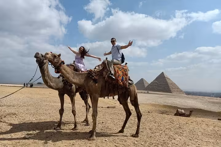 Couple on camel ride with the Giza Pyramids in the background on a private tour near the Sphinx