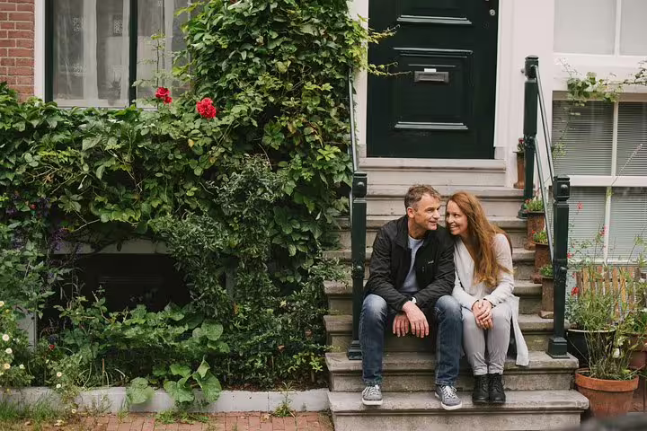 Couple sitting on canal house steps in Amsterdam, lifestyle portraits from a private vacation photographer session