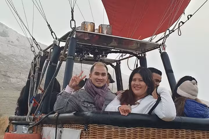 Smiling couple in Cappadocia hot air balloon basket before sunrise, 7 day 6 night express Turkey tour