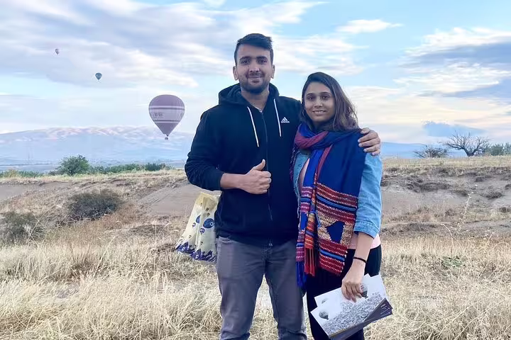 Couple enjoying a scenic view with hot air balloons in Cappadocia, ideal for a memorable private tour adventure.