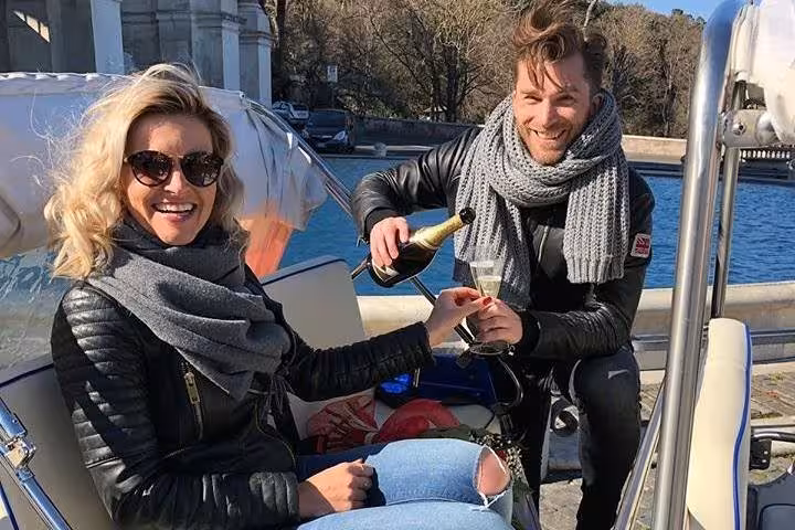 Couple enjoying champagne on a romantic Valentine buggy tour by the river in Rome, perfect for a unique city experience.