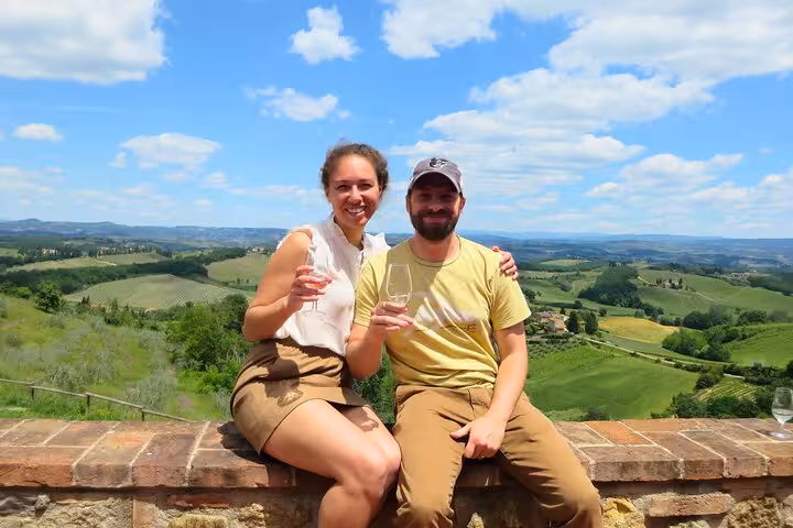 Couple enjoying wine with panoramic views of Tuscany's rolling hills on a Chianti wine tour.