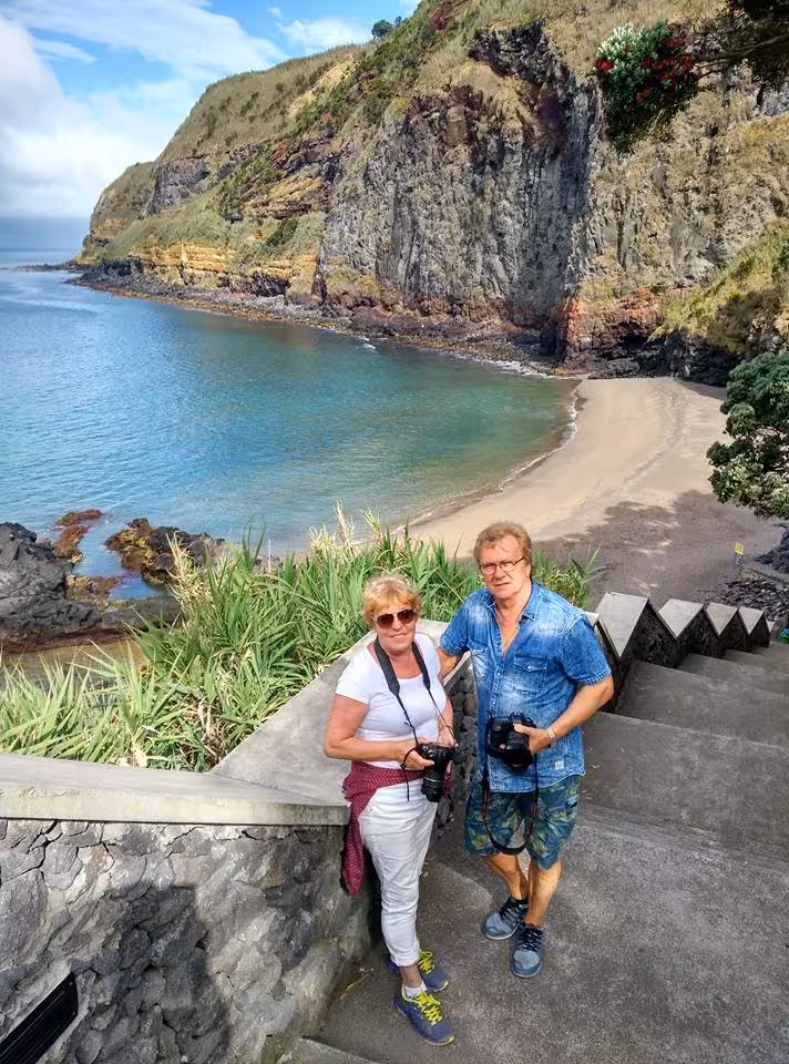 Couple at cliffside lookout above secluded beach on Northeast Scenic Tour, full-day van excursion in the Azores