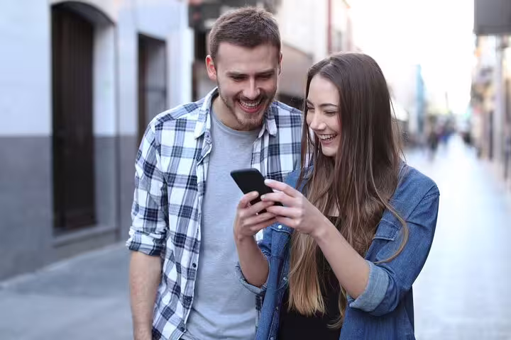 Couple using smartphone on Cognac streets during self-guided e-scavenger hunt city tour with interactive clues