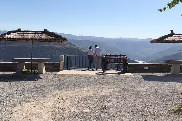 Couple enjoying a breathtaking view over Douro Valley from a scenic lookout during a private tour from Porto.