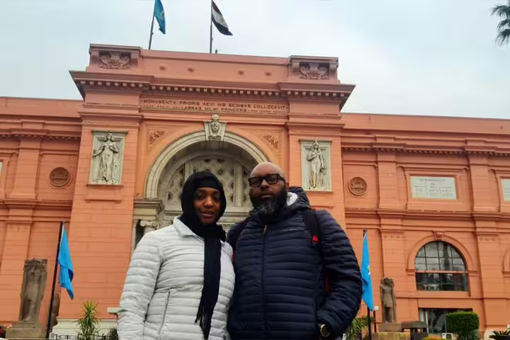 Couple posing at the Egyptian Museum Cairo entrance during a private half-day guided tour with guide